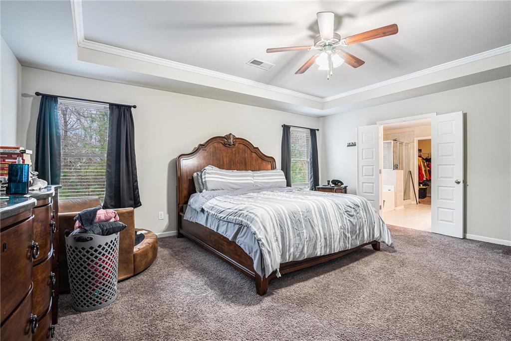 2428 Hanover Woods Road Lithonia, GA 30058 - Photo 14 of 26 a spacious bedroom with a bed and a chandelier