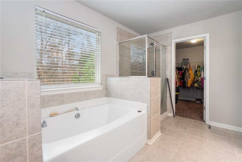 2428 Hanover Woods Road Lithonia, GA 30058 - Photo 17 of 26 a bathroom with a bathtub and a shower