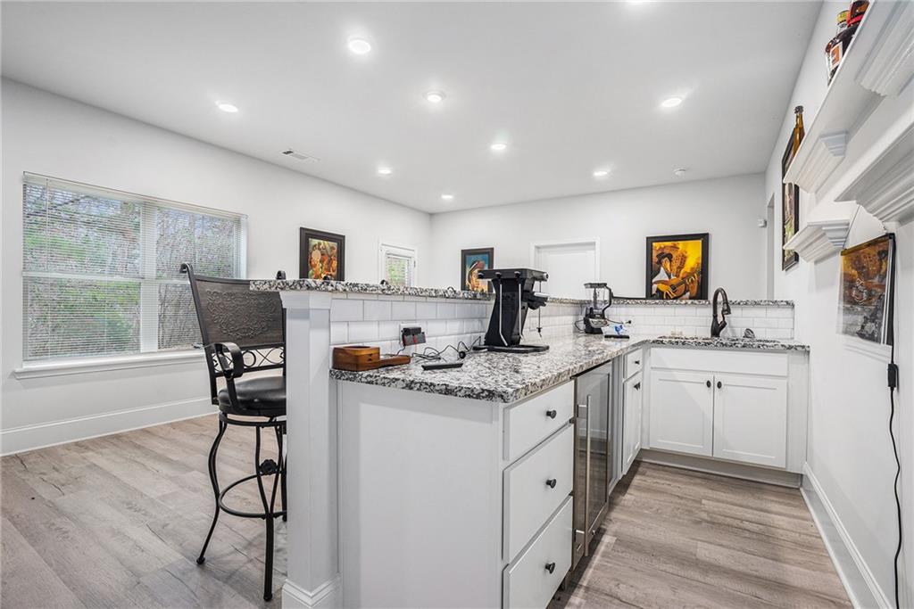 2428 Hanover Woods Road Lithonia, GA 30058 - Photo 20 of 26 a kitchen with granite countertop white cabinets and chairs