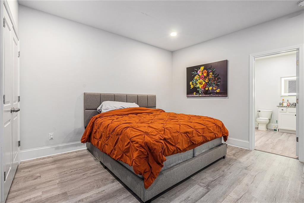2428 Hanover Woods Road Lithonia, GA 30058 - Photo 22 of 26 a bed sitting in a bedroom next to a bathroom