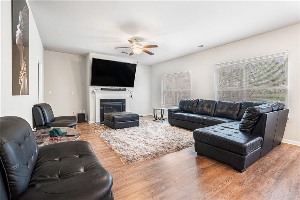 2428 Hanover Woods Road Lithonia, GA 30058 - Photo 6 of 26 a living room with furniture a flat screen tv and a fireplace