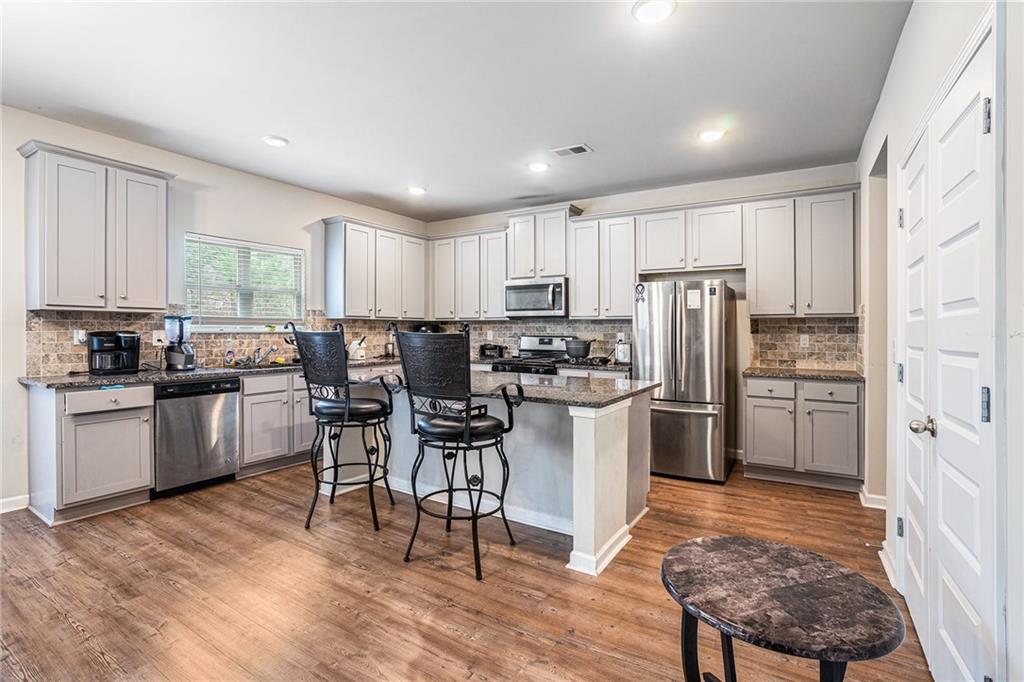 2428 Hanover Woods Road Lithonia, GA 30058 - Photo 7 of 26 a kitchen with a refrigerator and a wooden cabinets