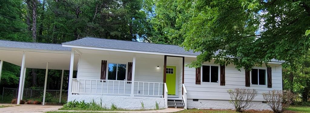 550 Pineland Circle Mableton, GA 30126 - Photo 1 of 1 a view of a white house with large windows and a small yard