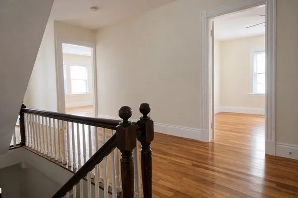a view of a hallway with wooden floor and staircase