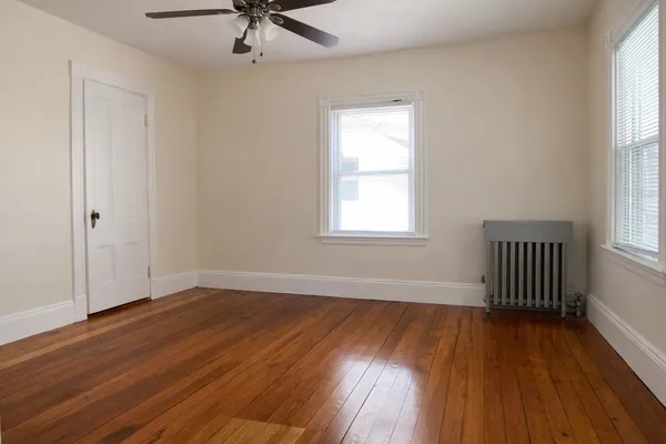 wooden floor in an empty room with a window