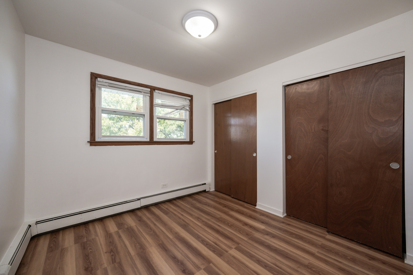 14450 Jefferson Avenue, Unit 2E Orland Park, IL 60462 - Photo 6 of 8 a view of an empty room with wooden floor and a window