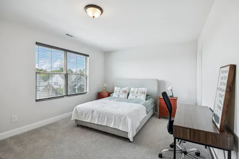 a bedroom with a bed and a chair in it