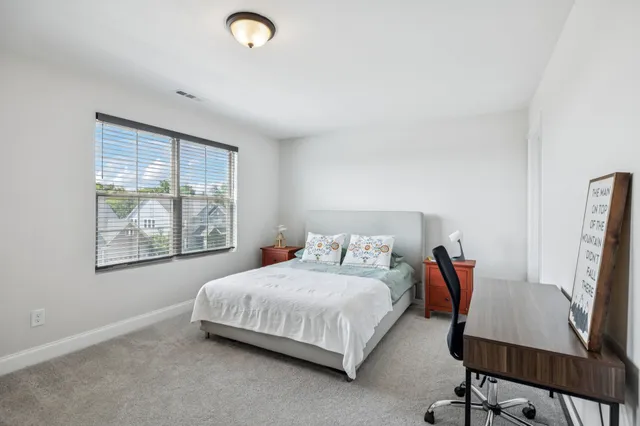 a bedroom with a bed and a chair in it