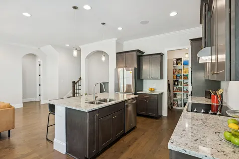 a large kitchen with a lot of counter space and wooden floor