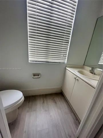a bathroom with a toilet and a wooden floor