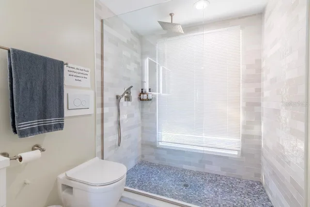 a bathroom with a double vanity sink a toilet and shower