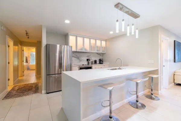 a kitchen with a refrigerator sink and stove top oven
