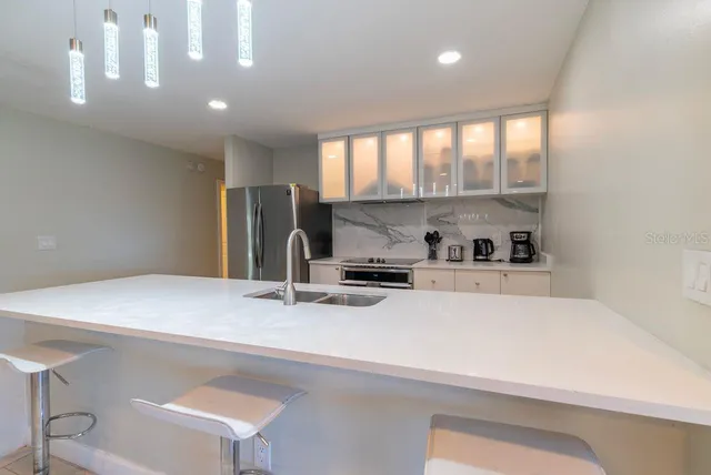 a living room with furniture and a view of kitchen
