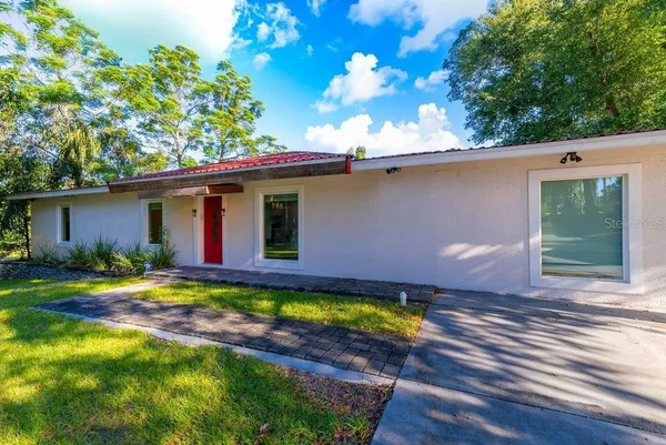 a bedroom with a bed and a lamp next to a window