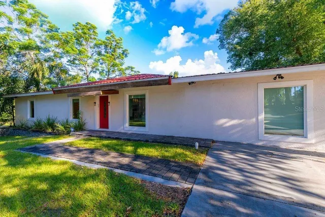 a bedroom with a bed and a lamp next to a window