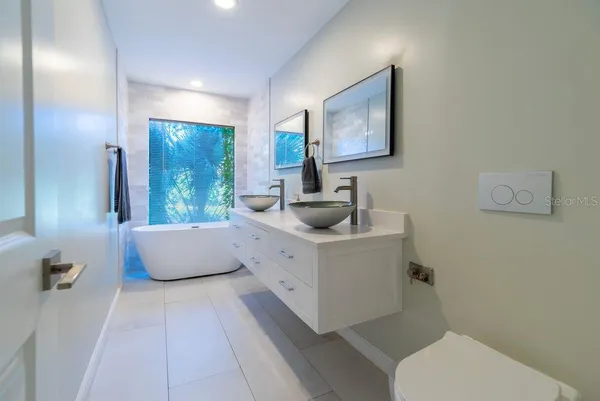 a bathroom with a granite countertop shower a toilet and a sink