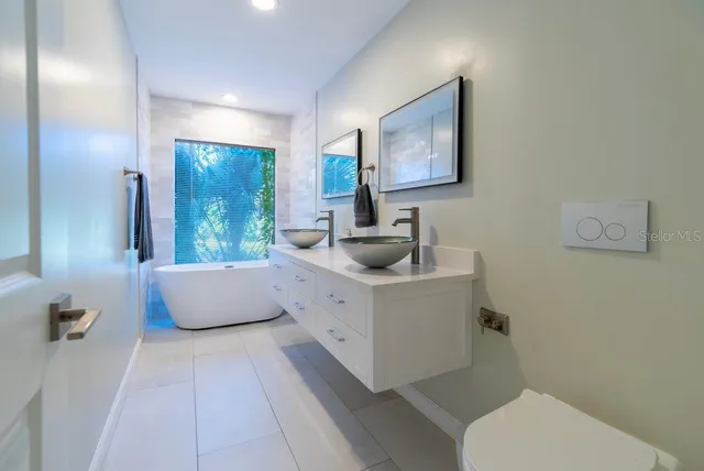 a bathroom with a granite countertop shower a toilet and a sink