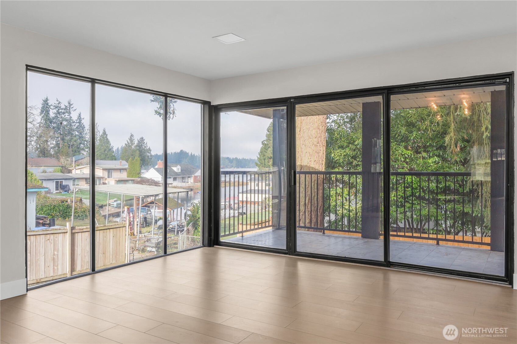 625 173rd Street South Spanaway, WA 98387 - Photo 12 of 35 a view of empty room with wooden floor and floor to ceiling window