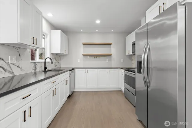 a kitchen with stainless steel appliances white cabinets and a stove