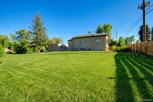 a view of a tree in front of a house with a yard