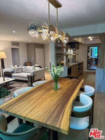 a room with lots of white furniture and wooden floor