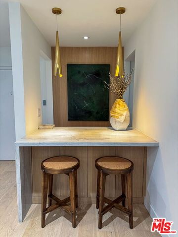 a kitchen with a sink a microwave and chairs