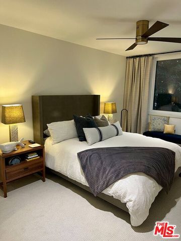 a spacious bedroom with a bed and a flat screen tv