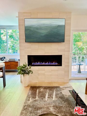 a living room with a fireplace and a floor to ceiling window