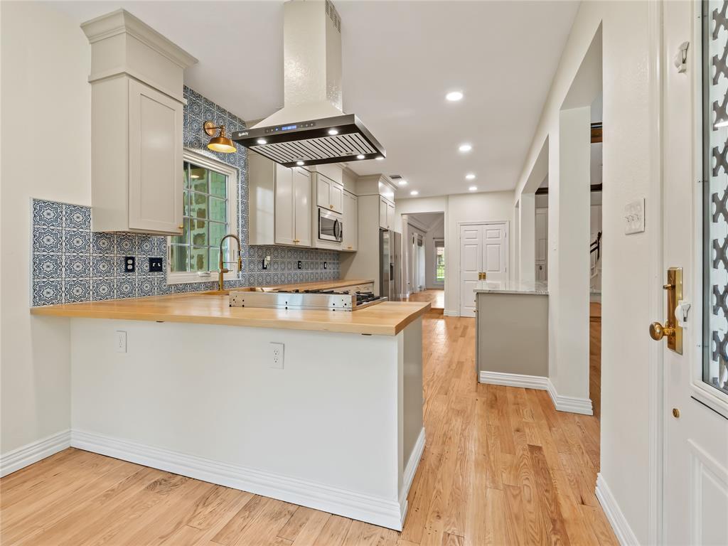 153 Meadowcreek Road Coppell, TX 75019 - Photo 11 of 35 Kitchen featuring extractor fan, healthy amount of natural light, a peninsula, light wood-style flooring, and recessed lighting