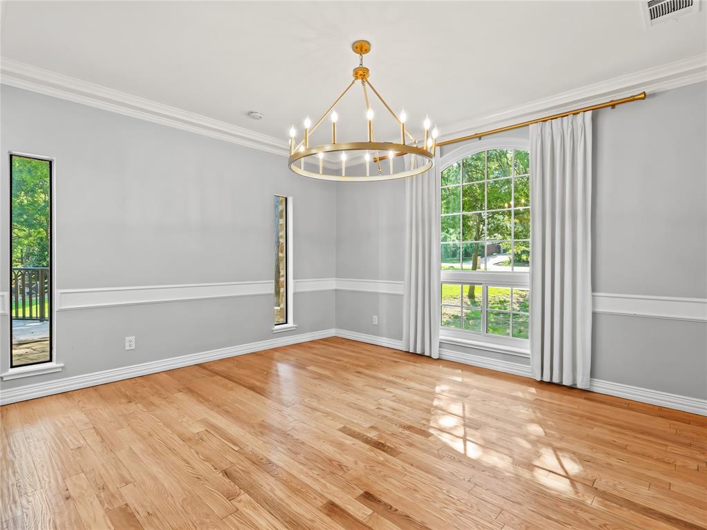 153 Meadowcreek Road Coppell, TX 75019 - Photo 16 of 35 Empty room featuring a chandelier, crown molding, and light wood-style floors