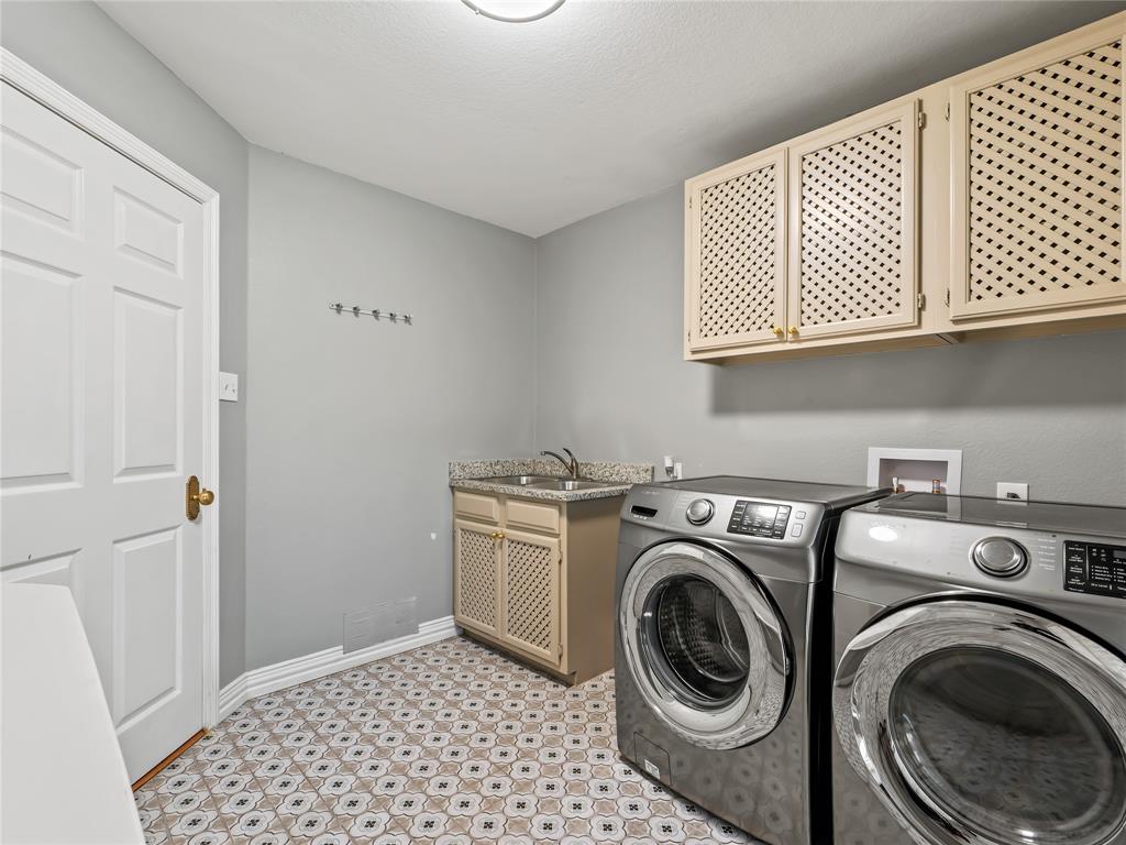 153 Meadowcreek Road Coppell, TX 75019 - Photo 19 of 35 Laundry room featuring independent washer and dryer, light flooring, and cabinet space
