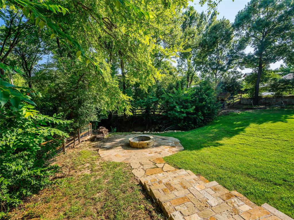 153 Meadowcreek Road Coppell, TX 75019 - Photo 33 of 35 Fenced backyard with an outdoor fire pit, a patio area, and view of wooded area