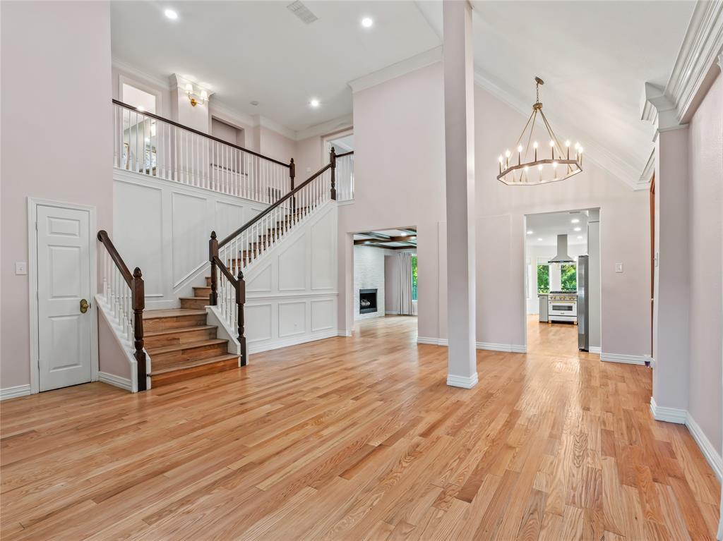 153 Meadowcreek Road Coppell, TX 75019 - Photo 4 of 35 Foyer with a high ceiling, ornamental molding, a fireplace, light wood-style floors, and a chandelier