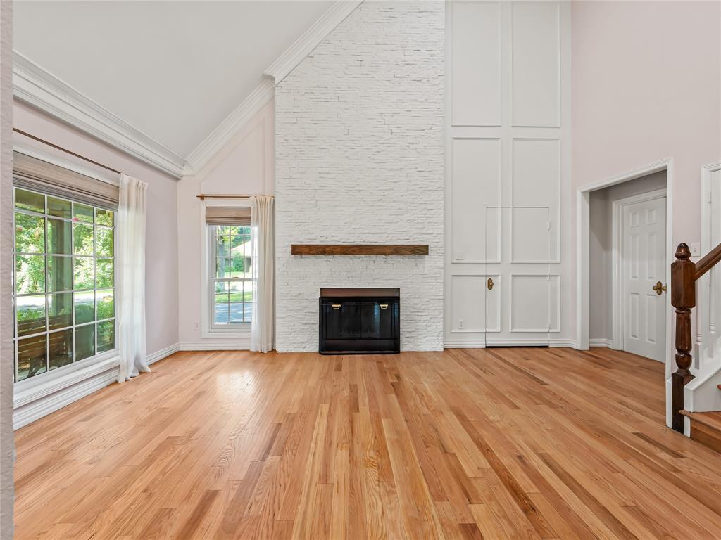 153 Meadowcreek Road Coppell, TX 75019 - Photo 7 of 35 Unfurnished living room with vaulted ceiling, light wood-type flooring, and a fireplace