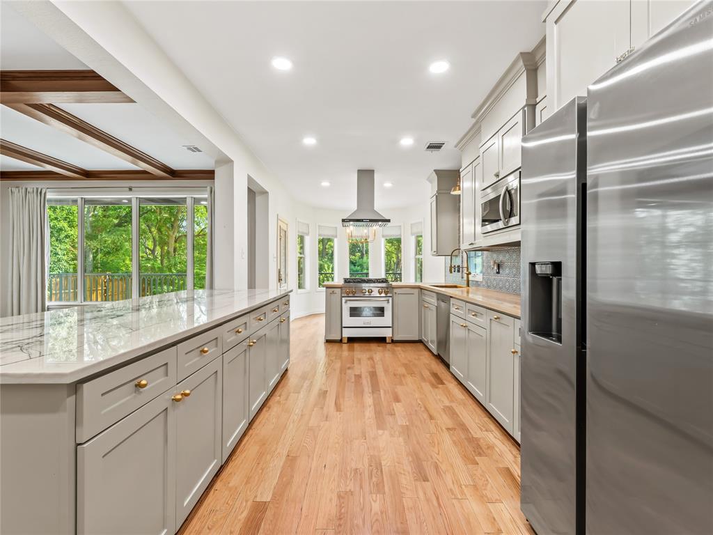 153 Meadowcreek Road Coppell, TX 75019 - Photo 9 of 35 Kitchen with stainless steel appliances, gray cabinetry, a peninsula, light wood-style flooring, and recessed lighting