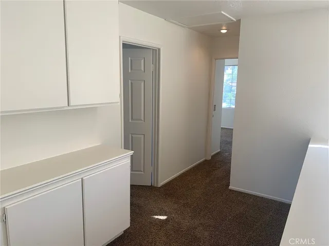 a view of an empty room with closet and a window