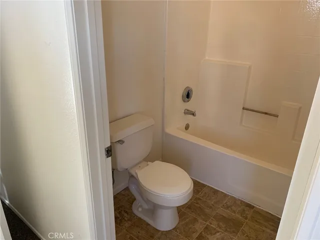 a white toilet sitting next to a bath tub