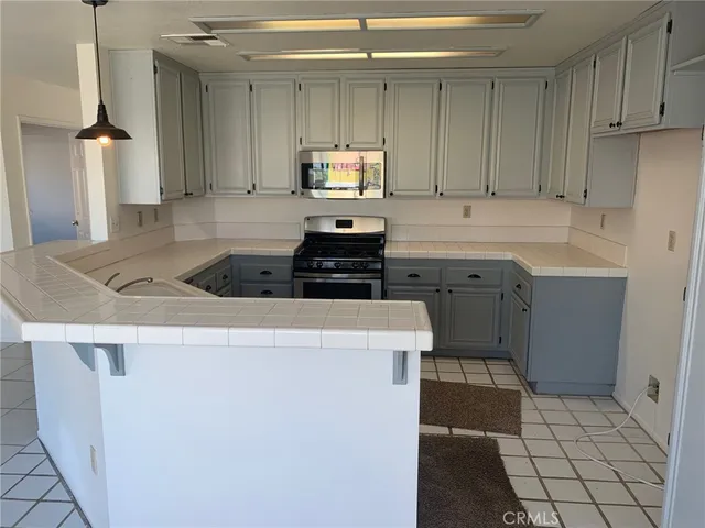 a kitchen with a sink a stove and cabinets
