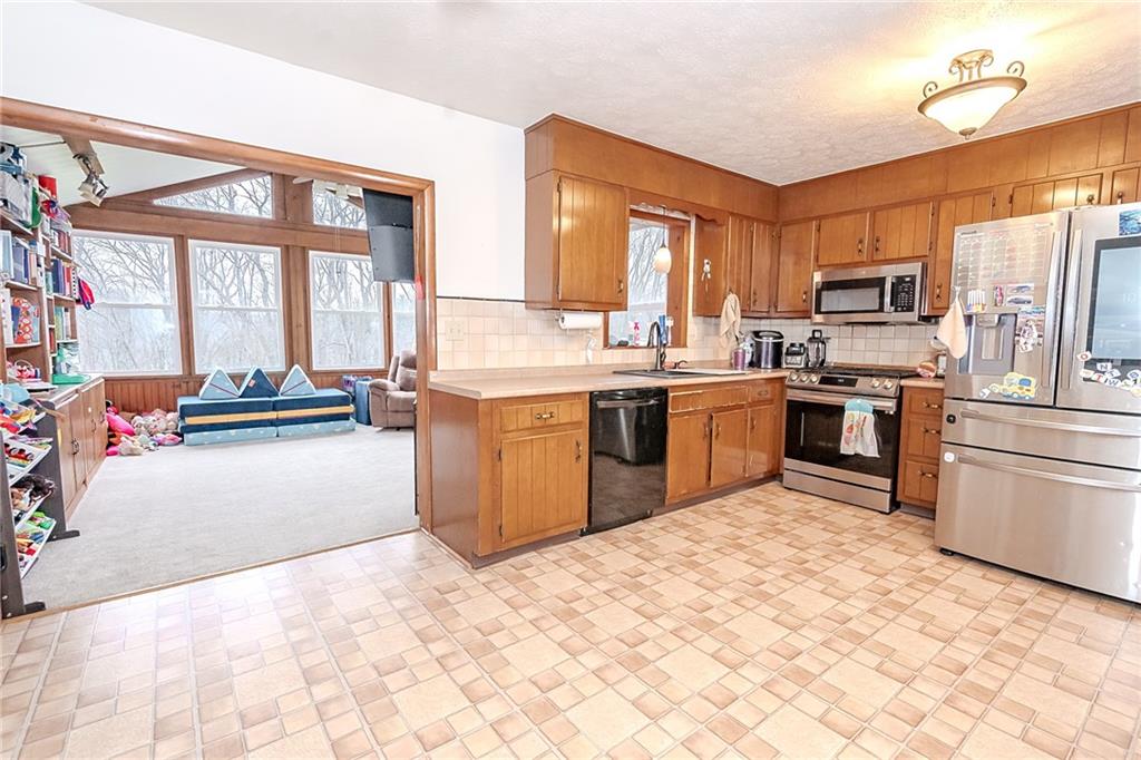 144 Stormer Road Indiana, PA 15701 - Photo 4 of 41 a kitchen with stainless steel appliances granite countertop a stove top oven a sink dishwasher a dining table and chairs with wooden floor