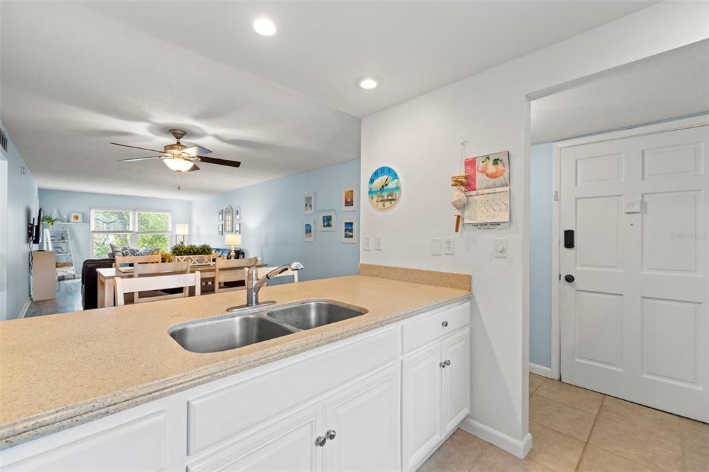 12760 Indian Rocks Road, Unit 107 Largo, FL 33774 - Photo 14 of 39 a kitchen with white cabinets and chandelier