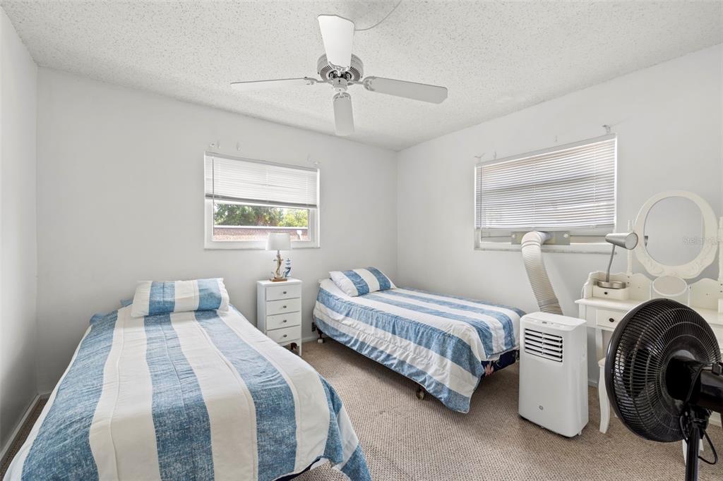 12760 Indian Rocks Road, Unit 107 Largo, FL 33774 - Photo 23 of 39 a bedroom with two beds and a chandelier