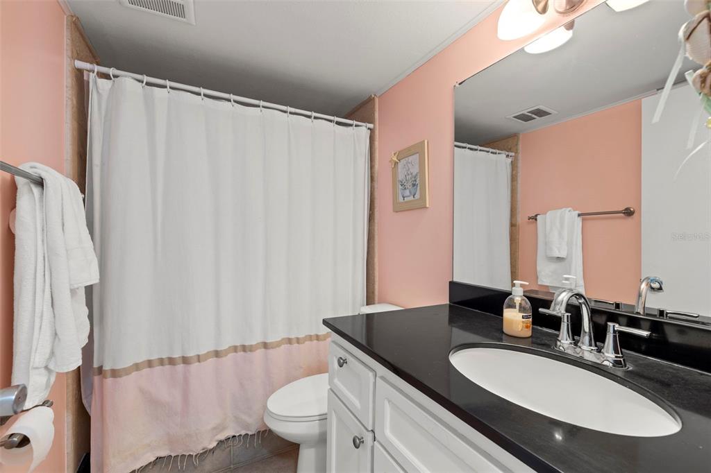 12760 Indian Rocks Road, Unit 107 Largo, FL 33774 - Photo 25 of 39 a bathroom with a granite countertop sink and a mirror