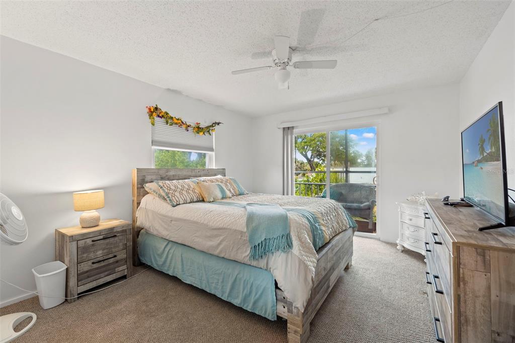 12760 Indian Rocks Road, Unit 107 Largo, FL 33774 - Photo 28 of 39 a bedroom with a bed a couch and a flat tv screen on dresser