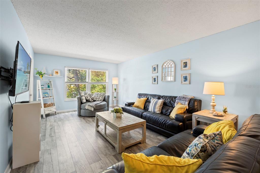 12760 Indian Rocks Road, Unit 107 Largo, FL 33774 - Photo 10 of 39 a living room with furniture and a flat screen tv