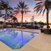 a swimming pool with outdoor seating and palm tree