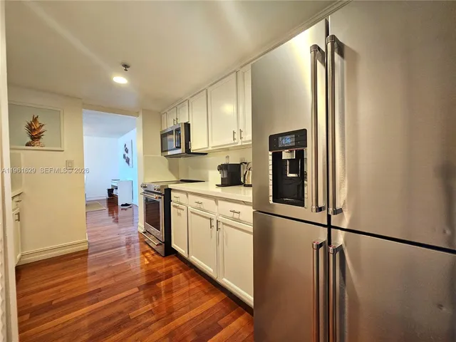 a kitchen with stainless steel appliances granite countertop a refrigerator and a stove top oven