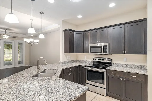 a kitchen with kitchen island granite countertop a sink stainless steel appliances and cabinets