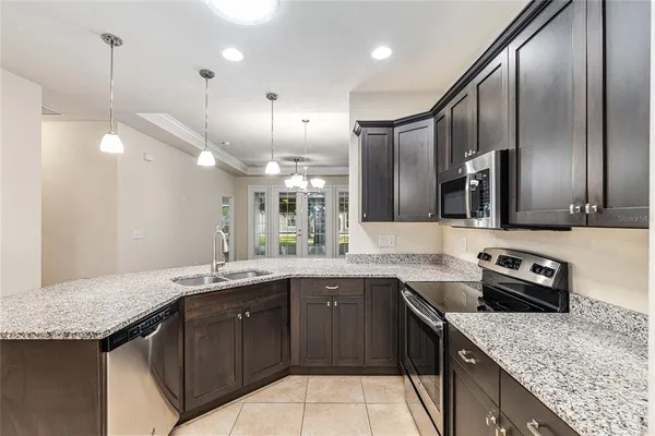 a kitchen with a sink a counter space appliances and cabinets