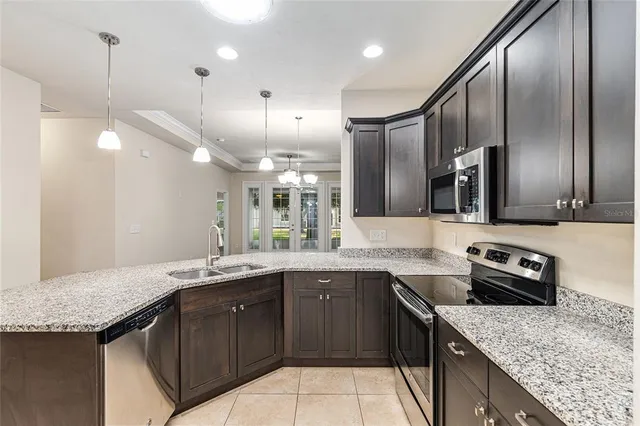 a kitchen with a sink a counter space appliances and cabinets