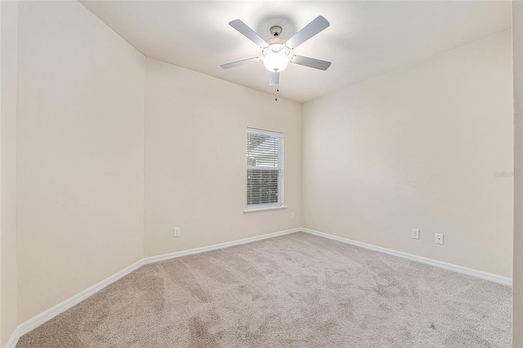 12731 Northwest 12th Road Newberry, FL 32669 - Photo 19 of 33 an empty room with a chandelier fan and windows